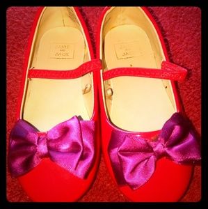 Red leather shoes with purple bow